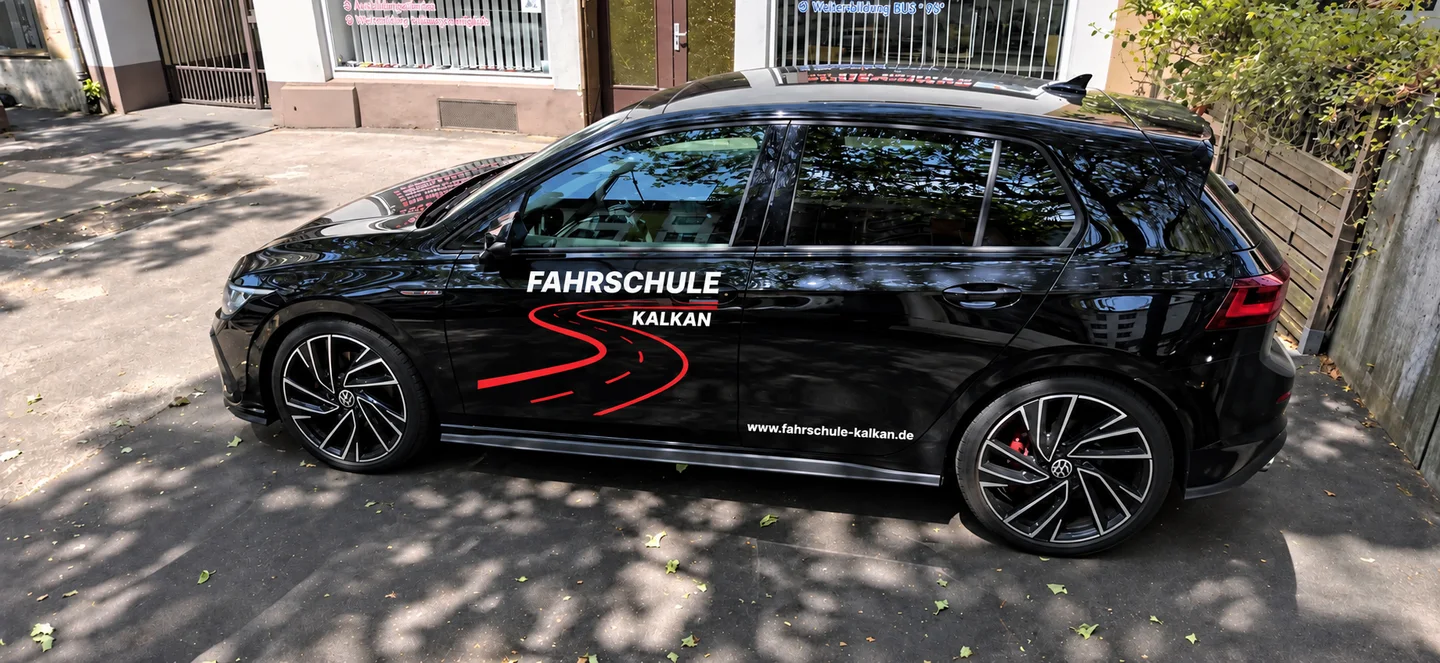 Schwarzer VW mit Fahrschule-Kalkan-Beschriftung von der Seite